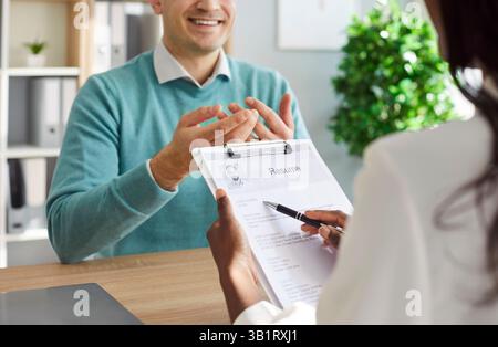 Young man sitting at the desk with african american HR manager on meeting. Stock Photo