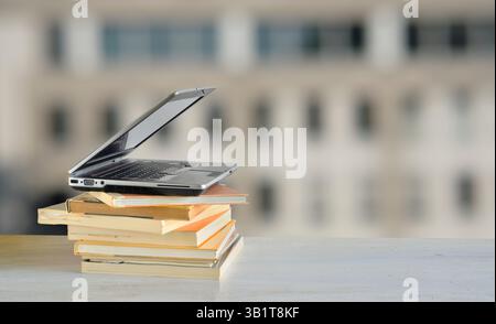 Laptop computer and stack of books Stock Photo