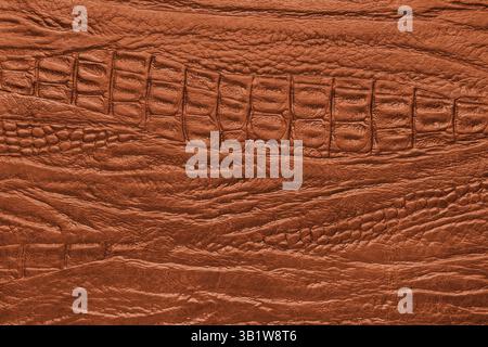 Crocodile genuine leather structure texture macro, orange colored leatherette surface with metallic, pearlescent effect. Reptile skin close up, macro Stock Photo