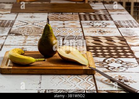 Fresh pear and banana on a wooden cutting board. Stock Photo