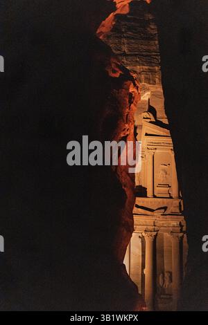 The Rose-Red City of Petra in Jordan, peaking at the illuminated the iconic Treasury through the valley for the great reveal of the treasury Stock Photo