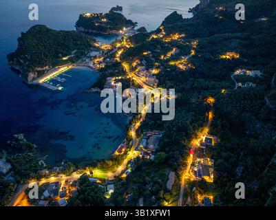 Aerial view of the illuminated harbor and coastline at night, featuring ...