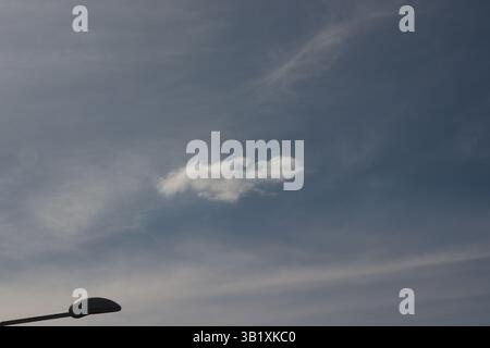 Sky covered by a thin layer of clouds with one thick cloud in the middle Stock Photo