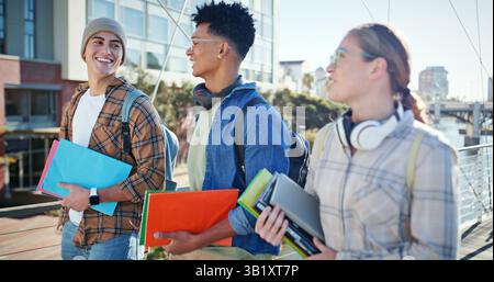 Students, books and walking at university for class, bonding and social in morning. People, happy and talk on campus for education, learning or Stock Photo