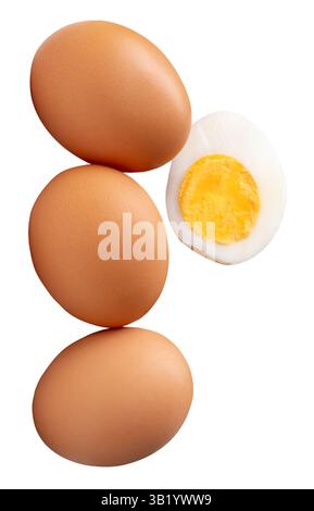 Front view of raw brown chicken eggs and cooked or boiled chicken egg with egg yolk in half in stack is isolated on white background. Stock Photo