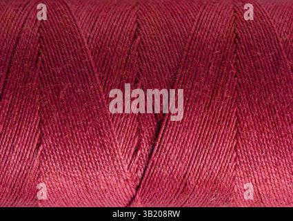 Macro close-up of fine dark pink cotton wound round spool background Stock Photo