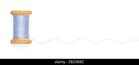 Old retro sewing blue colored thread spool unwound thread wave isolated on white background Stock Photo
