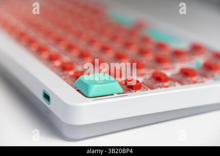 Macro shot of a mechanical keyboard featuring a teal ESC key among exposed red switches, showcasing a personalized setup focused on tactile response a Stock Photo