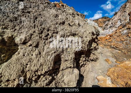 Detailed close-up of eroded volcanic rock texture with rugged surfaces and dry terrain at Sousaki Volcano near Agioi Theodoroi, Greece. Stock Photo