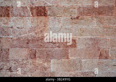 Texture of an old stone wall with a white or slightly rusty tint on certain stones Stock Photo