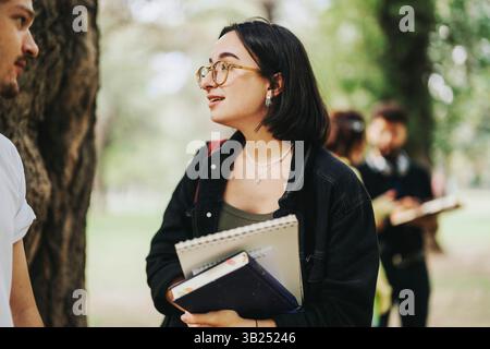 Multicultural students collaborating outdoors on academic projects in the park Stock Photo