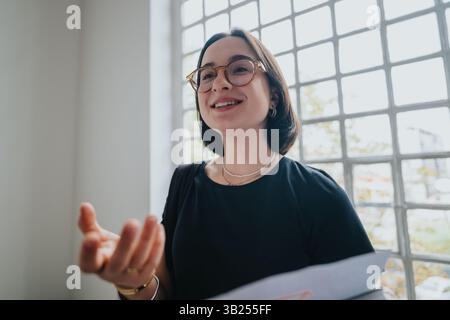 Confident professor engaging with students in a bright setting Stock Photo