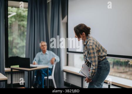 Students in a classroom engaging with an elderly professor Stock Photo