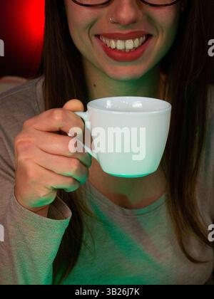 Relaxed Young Woman Smiling with a Cup of Coffee or Tea Stock Photo