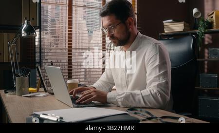Pensive thoughtful Caucasian manager worker employee male agent man working laptop businessman contemplate guy searching idea decision in office Stock Photo