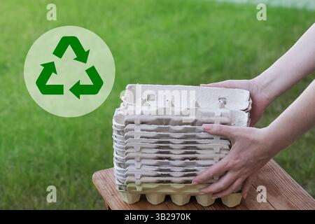 Empty Egg Cartons, Paper Container on Green Grass background. Recycling Concept Stock Photo