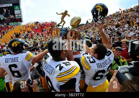 Iowa State players celebrate with the Cy-Hawk trophy after an NCAA ...