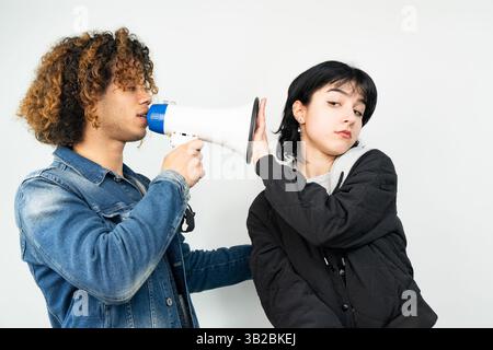 Young man shouting at his wife or girlfriend with a megaphone Stock Photo