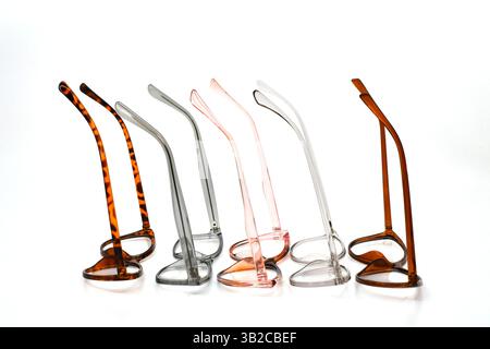 Row of glasses frames in a variety of colours isolated against a plain white background Stock Photo