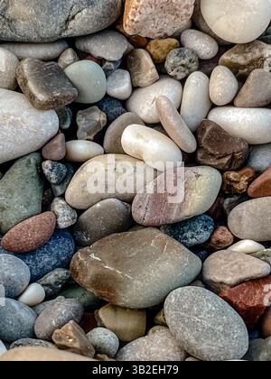 Close-up of smooth multicolored beach pebbles forming natural stone texture Stock Photo