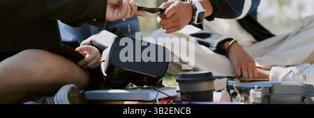 Website banner with two unrecognizable friends helping each other with drone Stock Photo