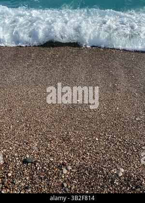 Sea wave breaking on a pebble beach with small stones in Antalya, Turkey. Stock Photo