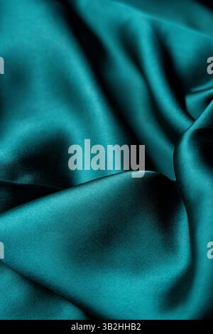 This shiny green satin fabric is smooth and rich in texture, perfect for creating a luxurious atmosphere or for showcasing high-quality textiles Stock Photo