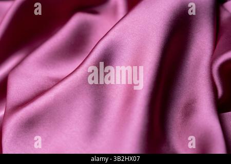Soft and smooth, this light pink satin fabric creates a luxurious feel with its glossy finish and gentle texture. Stock Photo