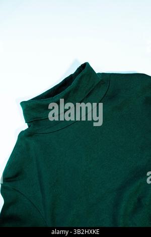 Elegant and simple green turtleneck shirt displayed flat against a white surface, highlighting the garment’s soft fabric and stylish look. Stock Photo