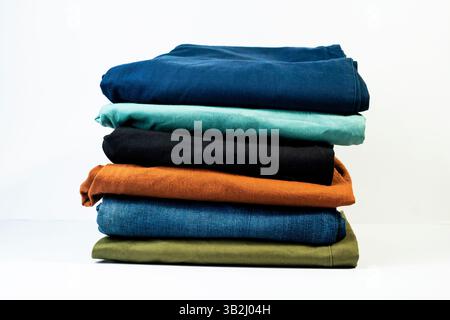 Casual pants in blue, green, orange, and black folded neatly together. isolated on white background Stock Photo