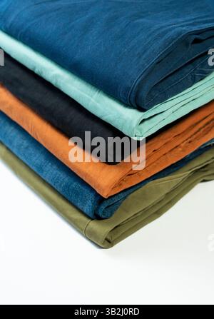 Different casual pants in many colors folded nicely on a white background. Stock Photo