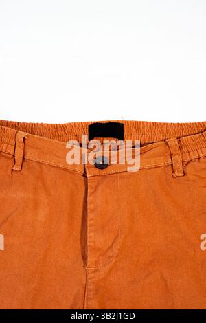 Stylish casual orange pants displayed flat on a simple white background. Stock Photo
