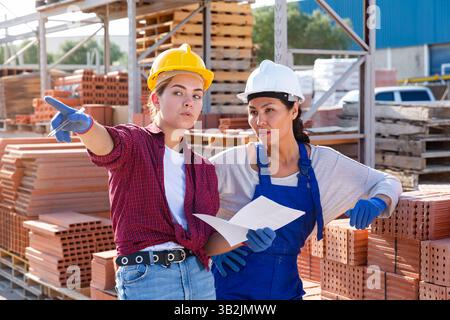 Female workers having conversation in outdoot warehouse Stock Photo