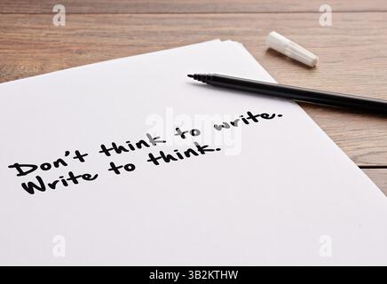 Act of writing and authorship. Writing and thinking. The motivational message don't think to write write to think, handwritten on a white sheet of pap Stock Photo