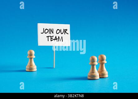 Chess pawn standing next to banner with the message Join Our Team. Employment, recruitment and career opportunities concept. Stock Photo