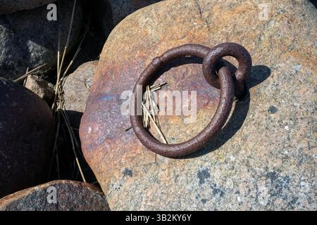 rusty old mooring ring on shore Stock Photo