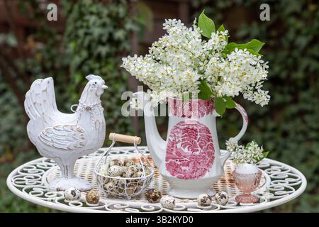 easter arrangement with bouquet of bird cherry blossoms, easter chicken and quail eggs Stock Photo