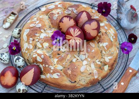 easter table arrangement with dyed easter eggs with leaf  motif and yeast wreath Stock Photo