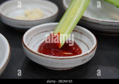 Fresh cucumbers dipped in gochujang sauce Stock Photo