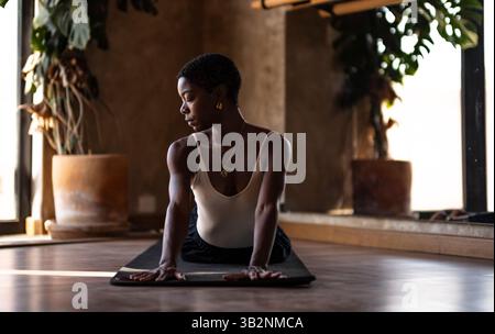 Young Black Woman Practicing Yoga and Meditation Indoors Stock Photo