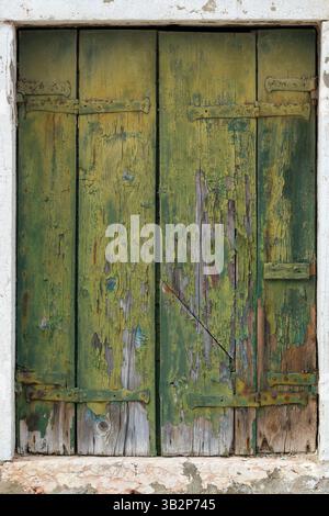 Old green wooden shutters with peeling paint Stock Photo