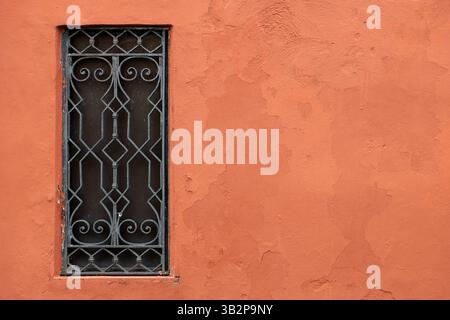 Decorative iron window on terracotta wall Stock Photo