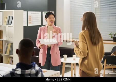 Asian Woman Explaining Language Concepts in Classroom Stock Photo