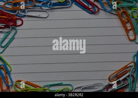 various color paper clips on notebook line paper background top view blank copy space Stock Photo