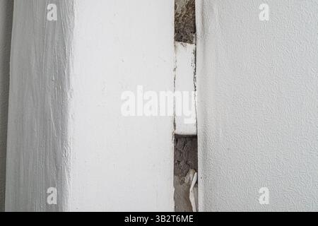 Wall Crack and Construction Defect in White Plastered Wall Stock Photo