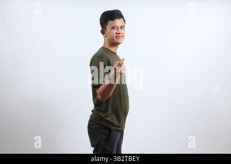 Asian man wearing green t-shirt smiling giving love sign isolated on white background Stock Photo
