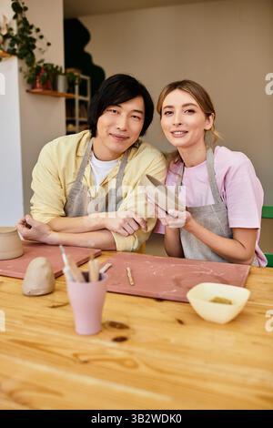 A young couple enjoys crafting pottery, engaging in a fun and romantic activity at the studio. Stock Photo
