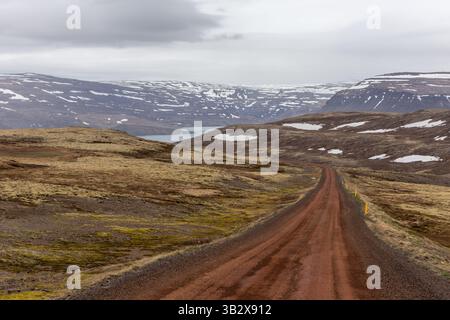 Dirt winding road through the rugged mountains covered with snow in Patreksfjordur, Westfjords, Iceland. Stock Photo