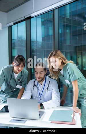 Doctors practitioners in hospital discussing care plan using digital tools Stock Photo