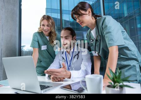 Doctors practitioners in hospital discussing care plan using digital tools Stock Photo